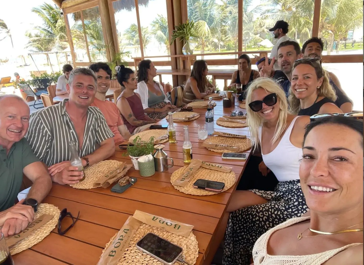 The crew around one long table for lunch at an open-air beach restaurant
